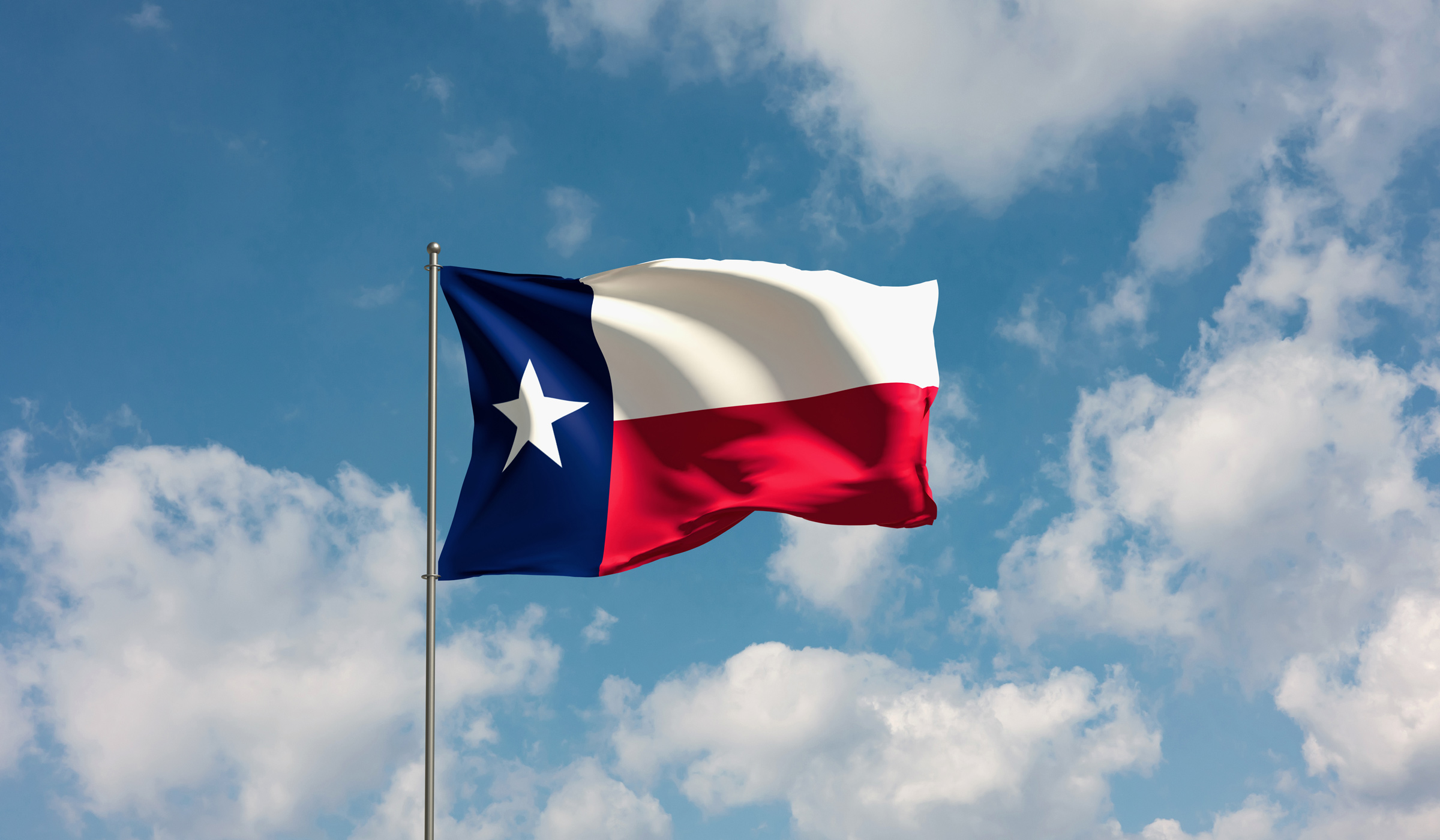 Texas state flag waving in blue sky