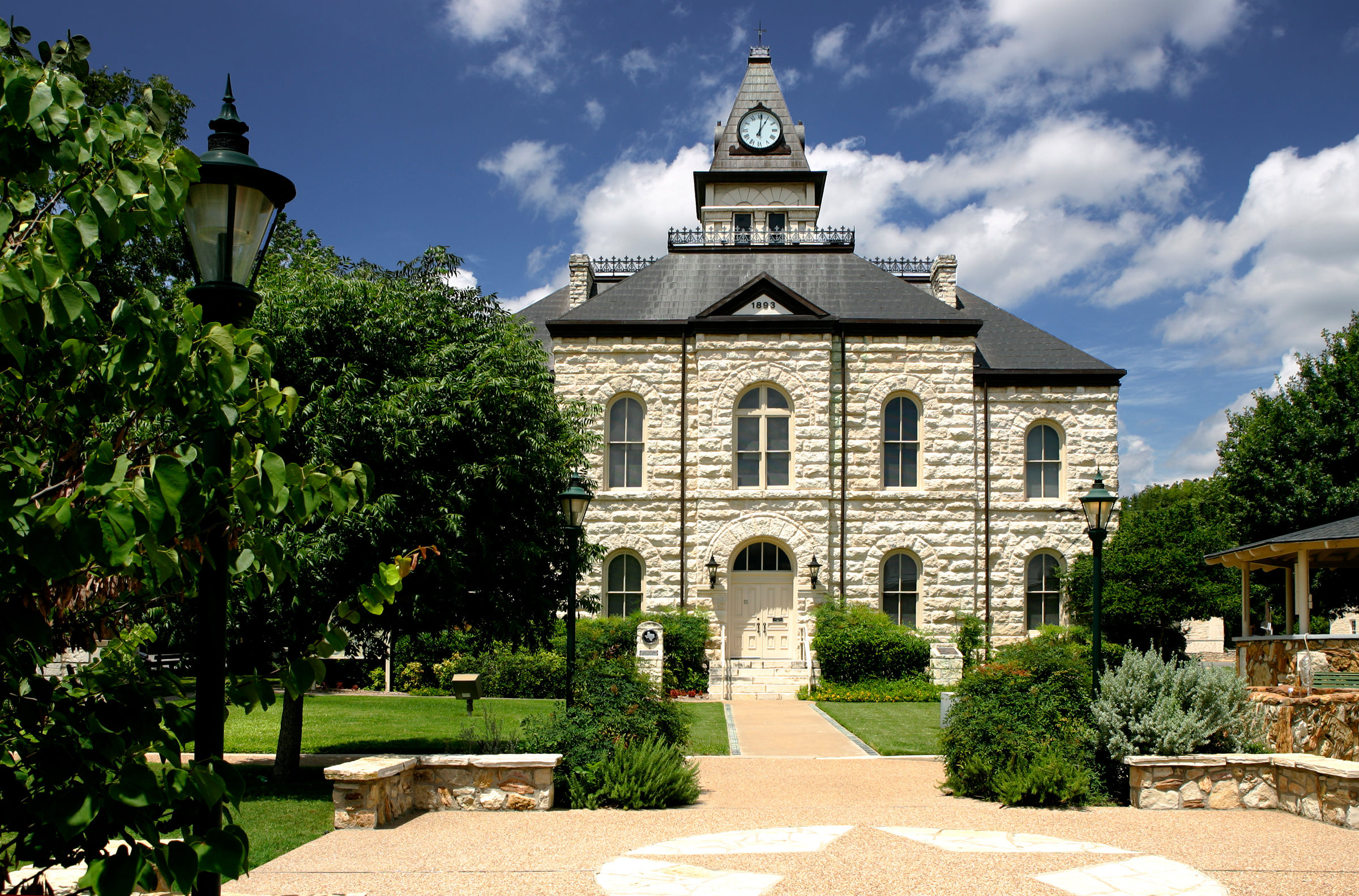 Historic Glen Rose courthouse with clock tower and garden