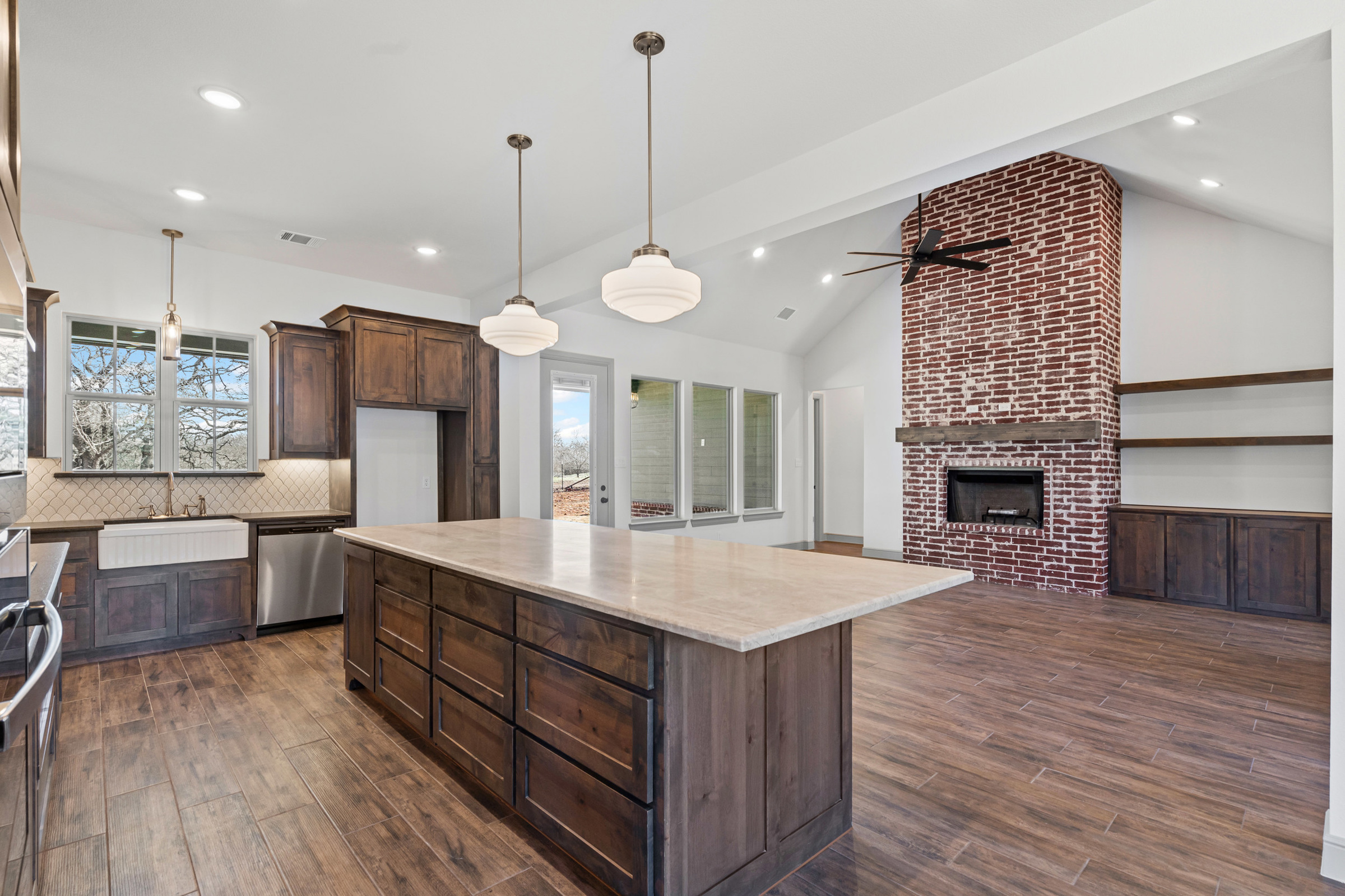 Spacious kitchen with island and brick fireplace.