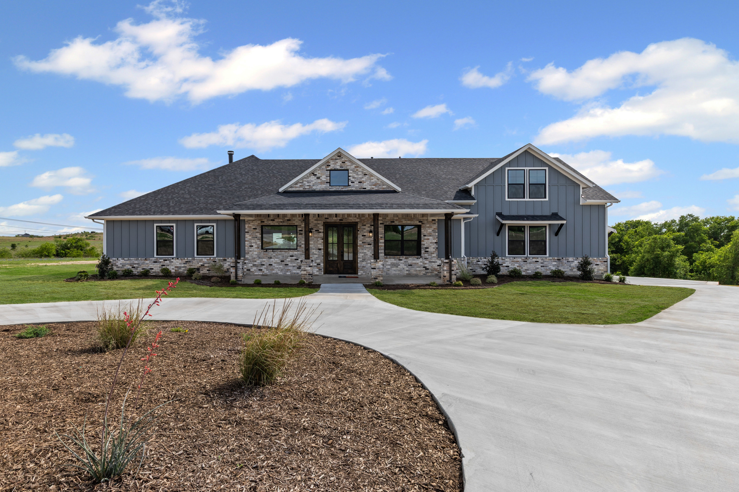 Modern farmhouse with landscaped front yard.